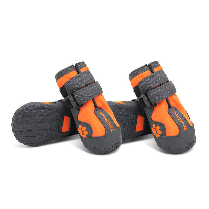Set of four orange and black dog boots with rugged anti-slip soles and reflective Velcro straps for secure fit and paw protection.