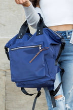 A woman is wearing a Everyday Backpack Tote. She is dressed in casual clothes and s smiling.