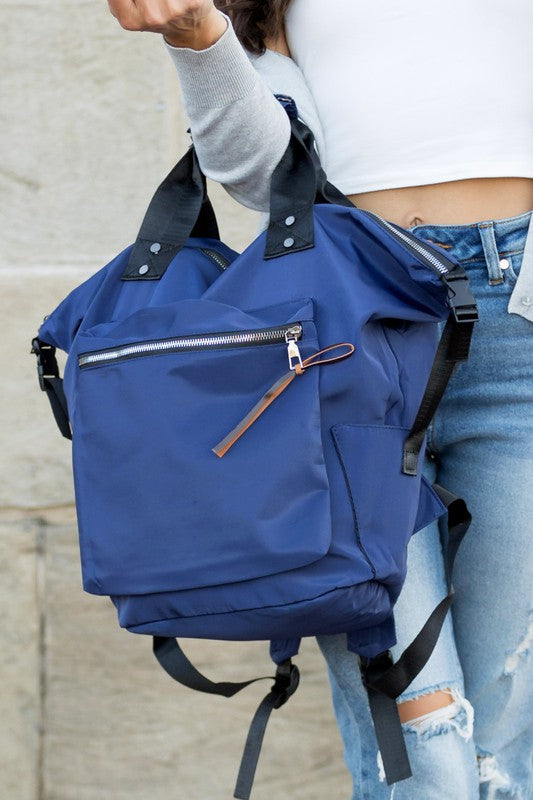 A woman is wearing a Everyday Backpack Tote. She is dressed in casual clothes and s smiling.