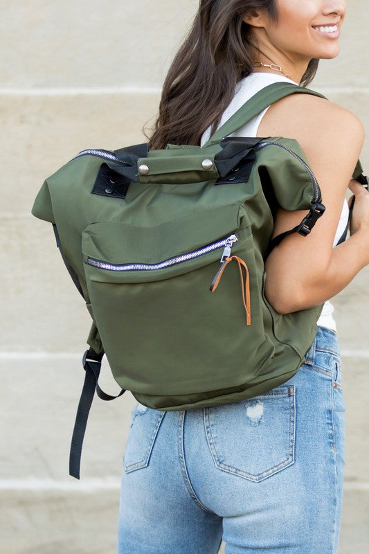A woman is wearing a Everyday Backpack Tote. She is dressed in casual clothes and s smiling.