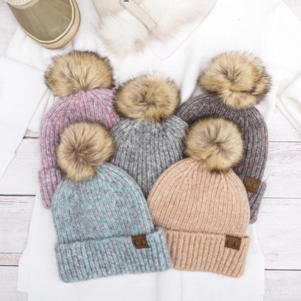 Assortment of cozy marled knit beanies with faux fur pom-poms, available in multiple colors.