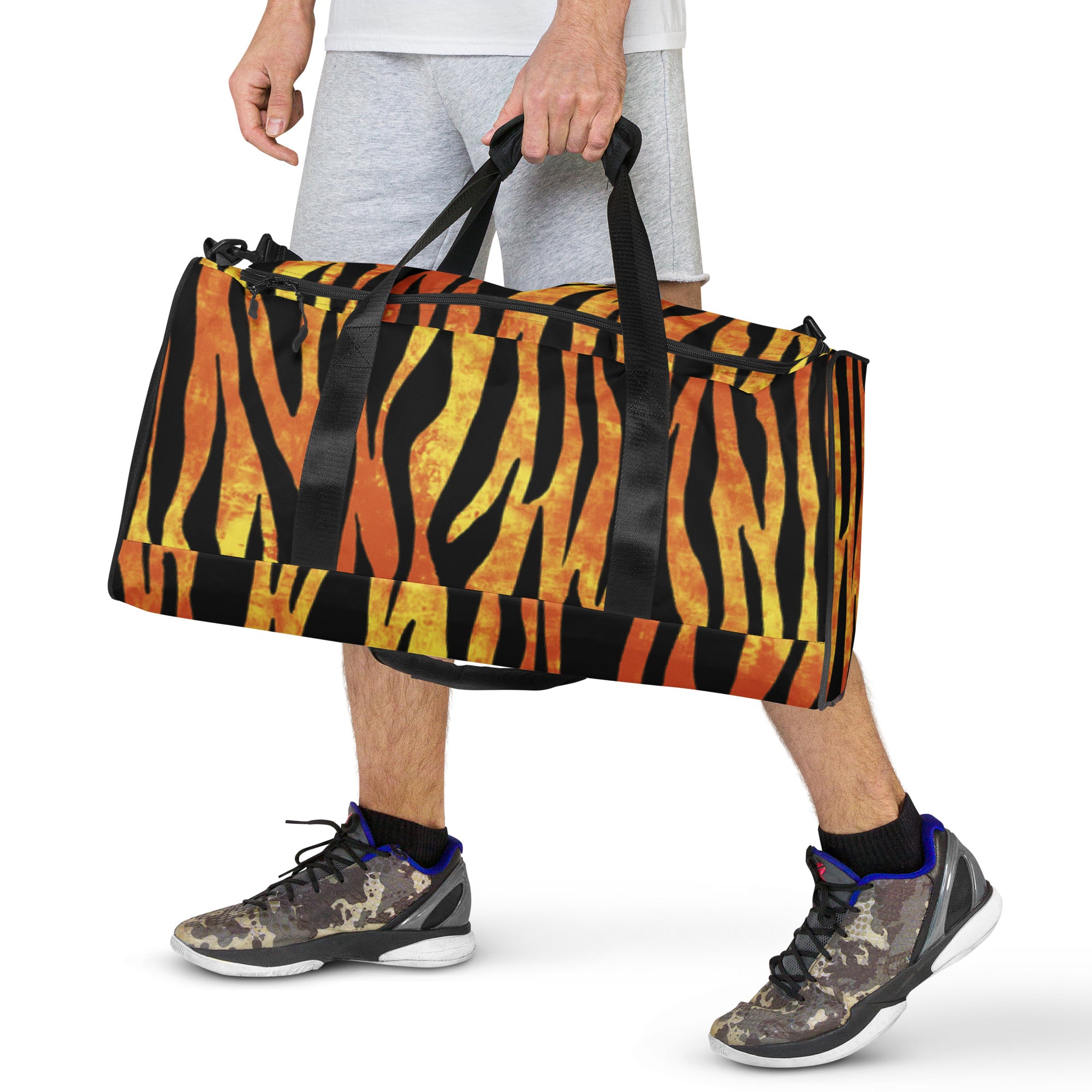 Man holding tiger-striped duffle bag by the handle.