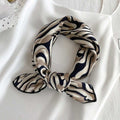 Versatile silk scarf folded on a white background