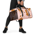 Woman holding a pink cheetah-print duffle bag with mesh side pocket and black straps