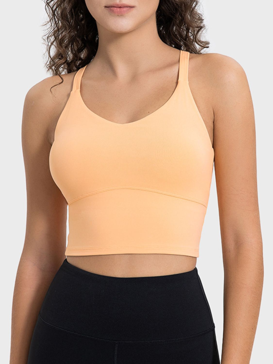 Woman wearing  a Sherbet color crisscross back active tank.