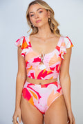 Woman wearing a vibrant floral print two-piece swimsuit with ruffled shoulder straps, V-shaped metallic detail at the bust, and high-waisted bikini bottoms.
