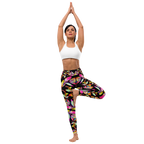 Woman wearing high-waist yoga leggings with a vibrant floral print on a black background, performing a tree pose in a white sports bra. Designed for comfort, flexibility, and activewear fashion.